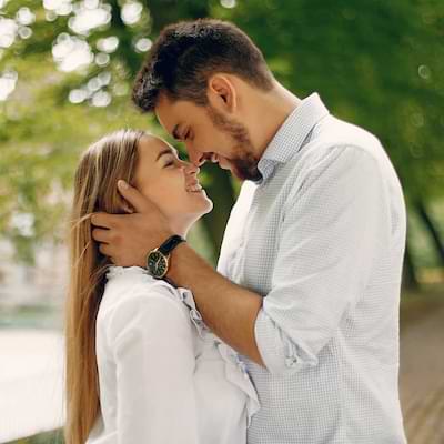 A joyful couple stands intimately close